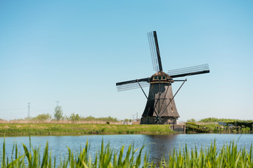 Netherlands landscape with a windmill and water canal.