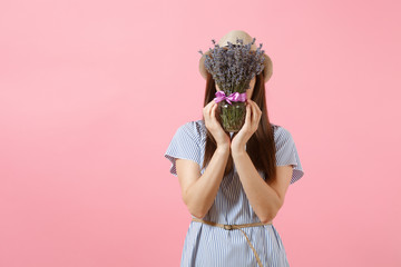 Portrait of a happy young tender woman in blue dress, hat holding bouquet of beautiful purple lavender flowers isolated on bright trending pink background. International Women's Day holiday concept.