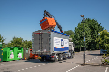 lorry emptying recycling bins in recycling area for bottles cans and cardboard in car park