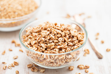 spelt in glass bowl on wooden background