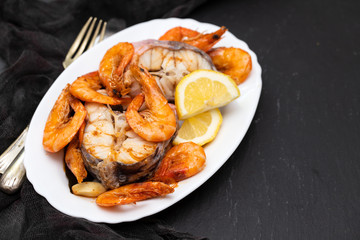 boiled fish with shrimps and lemon on white dish