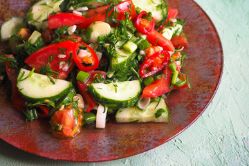 Cucumber salad and tomato with chili pepper and green onions seasoned with olive oil. Light summer vegetable salad.