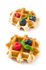 Traditional belgian waffles with blueberries and raspberries isolated on white background. 