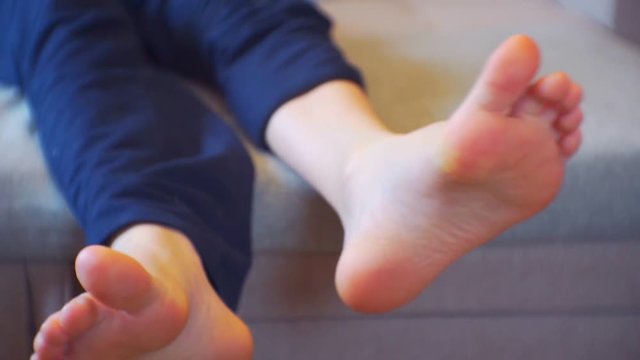 children's legs without socks carefree lying on the couch