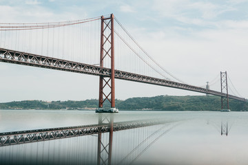 Bridge called April 25 in Lisbon in Portugal with reflection in water