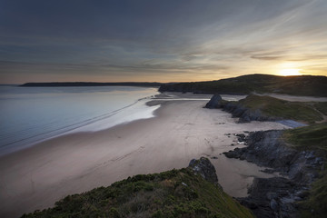 Sunset at Three Cliffs Bay and The Great Tor on the Gower peninsula, Swansea, South Wales, UK
