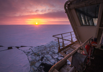 View from the wheelhouse of the Russian icebreaker on the Arctic sunset. Travel across the Kara sea. - obrazy, fototapety, plakaty