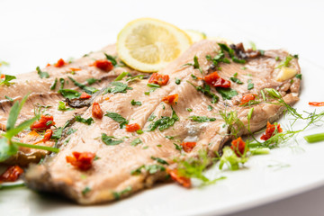 Piatto di trota salmonata con pomodori secchi e prezzemolo 