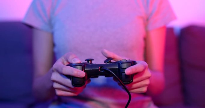 Woman play game on console at home