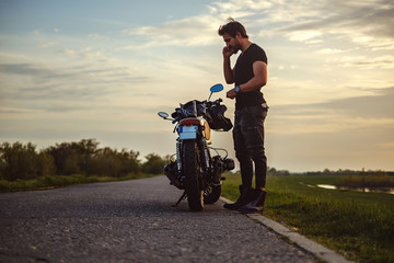 Man talking on the phone seriously and looking at bike