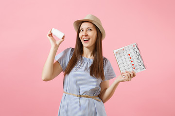Portrait of young woman in blue dress holding white bottle with pills, female periods calendar, checking menstruation days isolated on background. Medical healthcare gynecological concept. Copy space.
