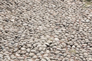 Texture of beige and gray stones on the ground. Grunge background.
