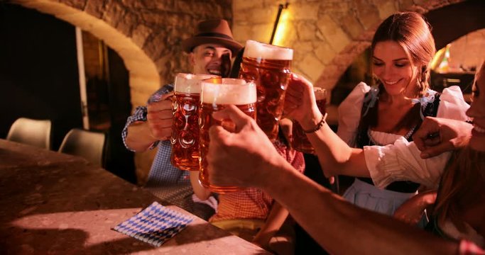 Multi-ethnic friends celebrating Oktoberfest festival and toasting with beer
