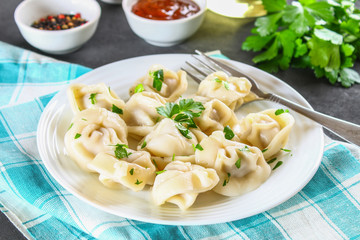 Homemade ready dumplings on a gray concrete table.