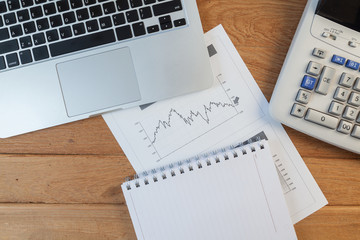 Open laptop with digital tablet and white smartphone, business and investment concept