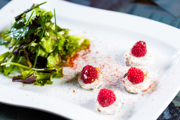 fresh salad with goat cheese and raspberry.