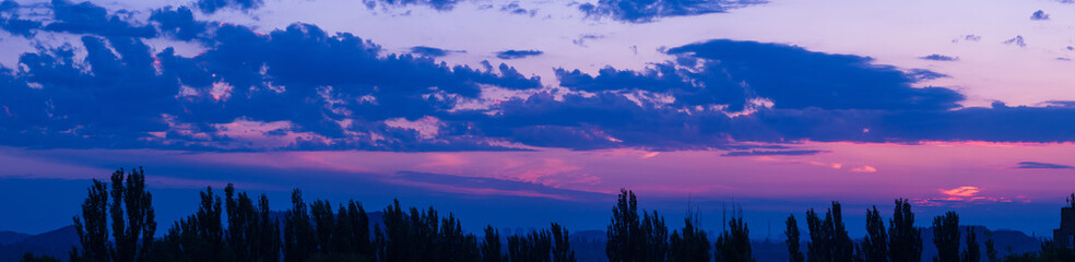 Landscape with dramatic light - beautiful golden sunset with saturated sky and clouds.