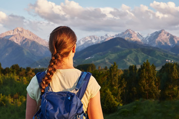 Young tourist woman looking at the peaks of the Almaty mountain. Almaty, Kazakhstan