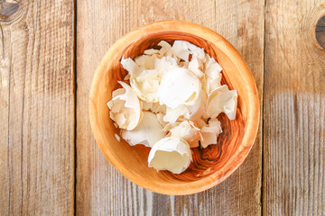 Male hands force the boiled chicken eggs through a vegetable cutter for okroshki on an old wooden table. Cutting eggs.