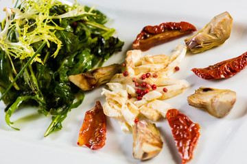 Fresh salad with sun-dried tomatoes and cheese in the Italian style.