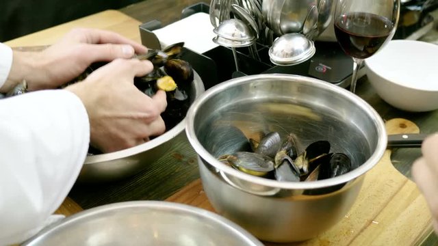 A group of people preparing mussels with cream at the cooking master class. 4K