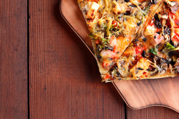 Pizza slices on a wooden board, Italian pizza on a wooden background top view, Italian food in vintage style, appetizing dish for summer vacation, American food, copy space, American food