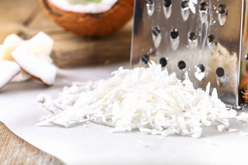 Fresh Grated Coconut, detailed close-up shot, on wooden background.
