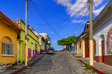 Fototapeta na wymiar Guatemala. Flores, El Peten. The old part of the city in colonial style with narrow cobblestone streets, red-roofed buildings and pastel houses