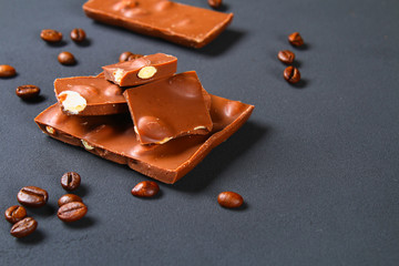 Coffee beans with chocolate on gray background.