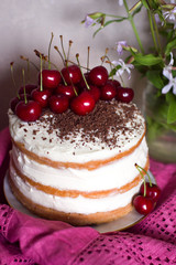Sponge cake with creamy cream with cherries and chocolate.