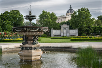 Fototapeta na wymiar Fountain in park with museum in background