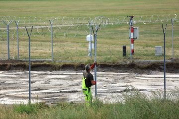 Budowa ogrodzenia, zakładanie drutu kolczastego wokół lotniska w Pyrzowicach.