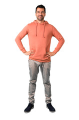 Fototapeta premium Full body of Man in a pink sweatshirt posing with arms at hip on isolated white background