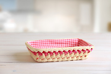 Straw basket at kitchen table empty space.