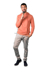 Full body of  Man in a pink sweatshirt holding a microphone and singing. on isolated white...
