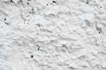 Rough Concrete Wall Decoration, Painted White. White Concrete Wall with Many Protruding Stones.