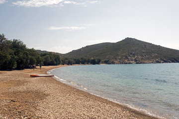 Fototapeta na wymiar A view of a beach and a canoe in the beautiful island of Patmos, Greece in summer