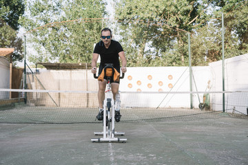 Man who performs physical activity with outdoor static bicycle