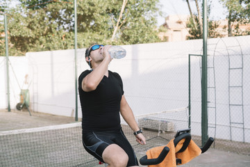 Man who performs physical activity with outdoor static bicycle