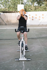 Man who performs physical activity with outdoor static bicycle