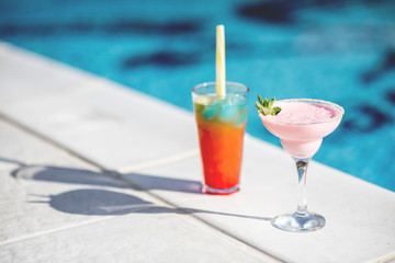 Close-up of summer cocktails on the beautiful blue water background during the sunlight