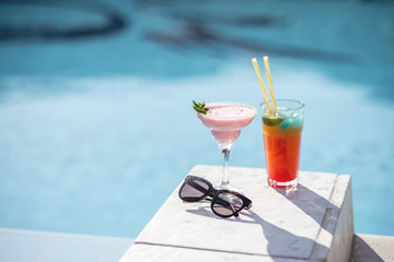 Close-up of summer cocktails on the beautiful blue water background during the sunlight