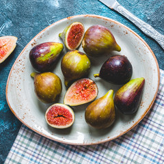 figs in a plate, knife, cut, blue background, seasonal fruits