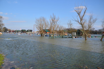 Fototapeta na wymiar Flooded promenade along a river bank in a city area