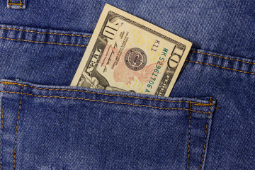 Ten dollars banknote in the pocket of blue jeans