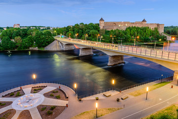 The ancient Russian fortress in Ivangorod and the beautiful promenade on the Bank of the Narova river, beautiful night view, Narva town, Estonia © r_andrei