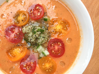 gazpacho soup with sliced tomatoes, cucumber, pepper and oil drops. top view. close-up