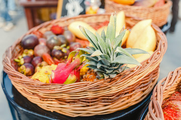 Basket with different tropical fresh fruits