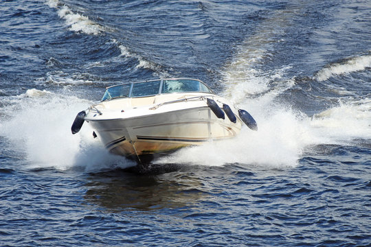 white motor boat flying fast on the waves