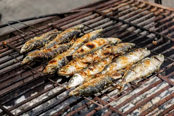 Fototapeten Grilled sardines and green peppers in Porto, Portugal on a grid grill, traditional food on festival Sao Joao © brunok1